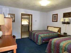 ein Hotelzimmer mit zwei Betten und einem Spiegel in der Unterkunft Wigwam Motel in Cody