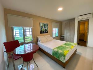 a bedroom with a bed and a table and chairs at Hotel La Esperanza Ciudad Jardín in Cali