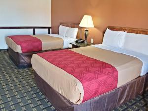 a hotel room with two beds and a lamp at Route 66 Inn in Shamrock