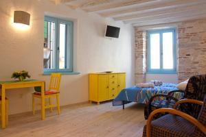 um quarto com uma cama e uma mesa e cadeiras amarelas em Studios Barbaro em Rovinj