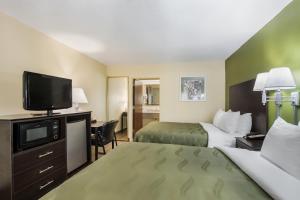 um quarto de hotel com duas camas e uma televisão de ecrã plano em Quality Inn Albany em Albany