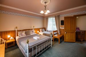 a bedroom with two beds and a table and a chair at Alexandria Bed and Breakfast in Wynyard