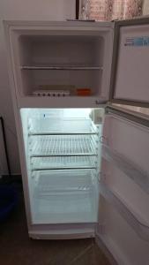 an open refrigerator with its door open and its door at Casa de Haydee in Cachí