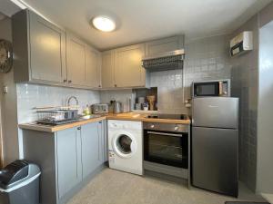 una cocina con lavadora y lavadora en Westend Holiday Let 1 Brecon, en Brecon 4 fotos más