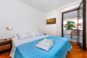 ein Schlafzimmer mit einem blauen Bett und Handtüchern darauf in der Unterkunft Apartments Marija - 500 m from beach in Rovinj