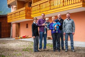 a family posing for a picture in front of a house at Apartments Masera in Kobarid