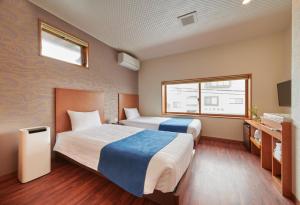 Kama o mga kama sa kuwarto sa Ichinomatsu Japanese Modern Hotel