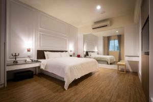 a bedroom with a large white bed and a window at Alegran Motel in Wuqi