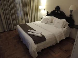 a bedroom with a large white bed with towels on it at GM Rooms Rental Suites in La Rioja