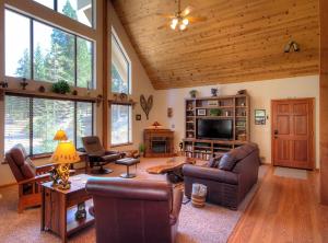 a living room with couches and a tv and windows at Mystic Views in Yosemite West
