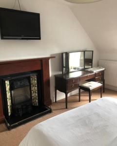 a bedroom with a fireplace and a tv on the wall at Jacobite Rose in Inverness