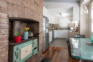 een keuken en een woonkamer met een bakstenen muur bij Blackheath Nook in Blackheath