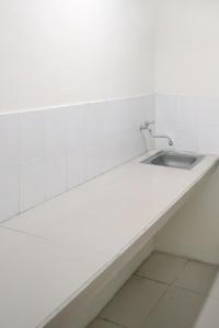- un comptoir blanc avec lavabo dans la chambre dans l'établissement DPARAGON PAMELA 4, à Yogyakarta
