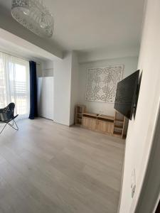 an empty living room with a television and a table at Velier Apartments 38 and 49 in Mamaia