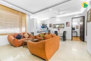 a living room with two couches and a table at Prestige Apartments in New Delhi