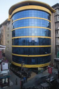 un grand bâtiment en verre avec un jaune dans l'établissement Jai Hotels, à Darjeeling