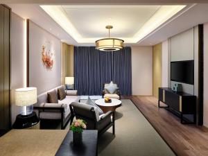 a living room with a couch and a tv at Primus Hotel Shanghai Sanjiagang - Offer Pudong International Airport and Disney shuttle in Shanghai