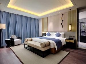 上海的住宿－上海三甲港绿地铂瑞酒店-提供浦东机场和迪士尼班车，一间卧室配有一张特大号床和一把椅子