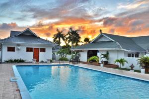 una villa con piscina di fronte a una casa di Britannia Hotel a Grand'Anse Praslin