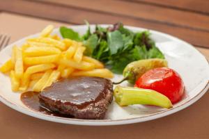 a plate of food with steak and french fries at Golden Orange Hotel in Antalya