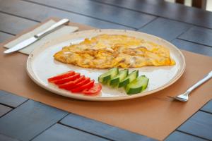 a plate of omelet and vegetables on a table at Golden Orange Hotel in Antalya