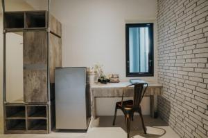 a kitchen with a refrigerator and a table and a chair at DPARAGON PERUMNAS in Yogyakarta