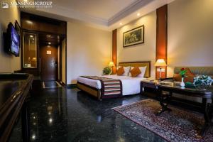 a hotel room with a bed and a desk at Mansingh Palace, Agra in Agra