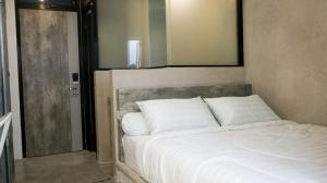 uma cama com almofadas brancas num quarto em DPARAGON BEO em Yogyakarta
