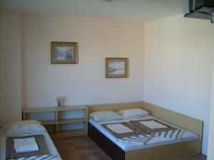 a small room with two beds and a table at Hotel Pasians in Pomorie