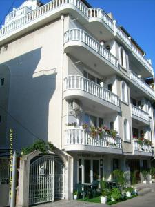 ein großes weißes Gebäude mit Balkon und Tisch in der Unterkunft Hotel Pasians in Pomorie