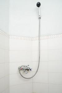 y baño de azulejos blancos con ducha. en DPARAGON MT HARYONO en Semarang