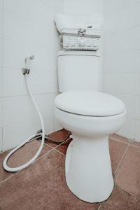 a white toilet in a bathroom with a hose at DPARAGON MT HARYONO in Semarang