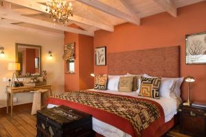 1 dormitorio con 1 cama grande y paredes de color naranja en Tintswalo Atlantic, en Hout Bay
