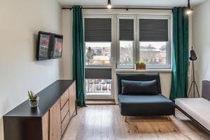 a living room with a couch and a chair at Apartament Loft in Giżycko