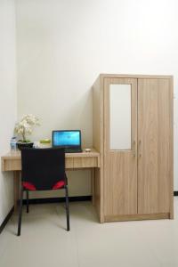 a desk with a laptop computer and a cabinet at DPARAGON SONGGOLANGIT in Malang