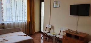 a hotel room with a bed and a tv on the wall at Vila Raduinea in Eforie Nord