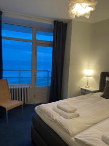 1 dormitorio con 1 cama y vistas al océano en De Steltloper en Zandvoort