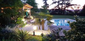 une arrière-cour avec une piscine et un kiosque dans l'établissement Château de Grandmont Gîte, à Blacé