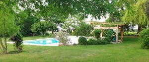 a swimming pool in a yard with a gazebo at Château de Grandmont Gîte in Blacé +10 photos