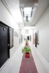 um corredor com vasos de plantas num edifício em DPARAGON DWIKORA em Palimbão