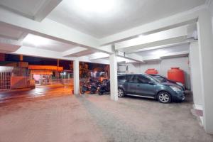 a garage with a car and motorcycles parked in it at DPARAGON DWIKORA in Palembang