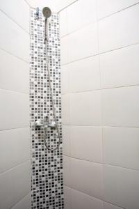 um chuveiro na casa de banho com uma parede de azulejos em DPARAGON DWIKORA em Palimbão