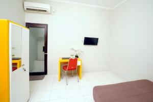 a room with a table and a red chair at DPARAGON DWIKORA in Palembang
