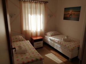 2 camas individuales en una habitación con ventana en Apartments Tina, en Pula