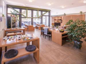 ein Restaurant mit Holztischen und -stühlen und Fenstern in der Unterkunft Ecoinn in Esslingen