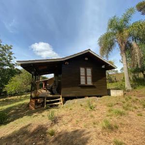 mały dom siedzący na szczycie wzgórza w obiekcie Pousada Aguaraguazu w mieście Tibagi