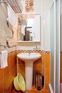 uma casa de banho com um lavatório e um espelho em Mini hotel Delphin em Adler