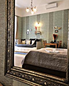 エゲルにあるCozy Loft Apartmanの鏡(ベッドルーム1室、ベッド1台、ソファ付)