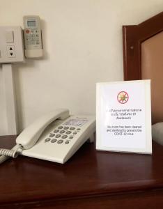 a phone sitting on a desk next to a book at At Bangkok Hotel in Bangkok