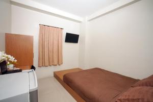 a bedroom with a bed and a television in it at DParagon Veteran in Banjarmasin